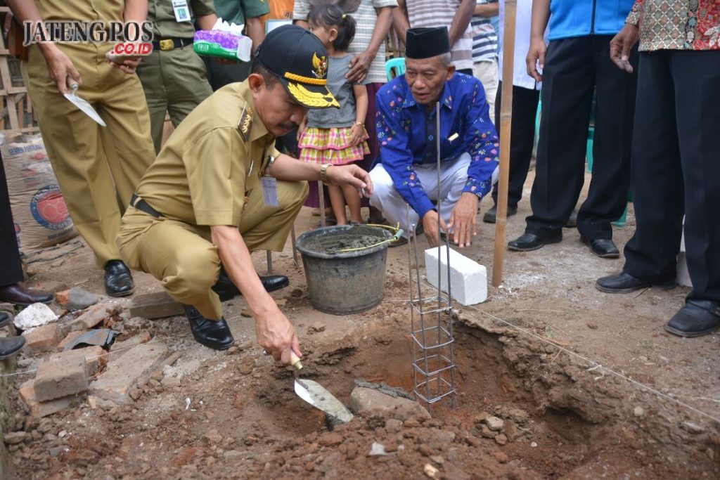 BATU PERTAMA: Bupati Haryanto meletakkan batu pertama pembangunan bedah rumah dari Baznas. foto:istimewa