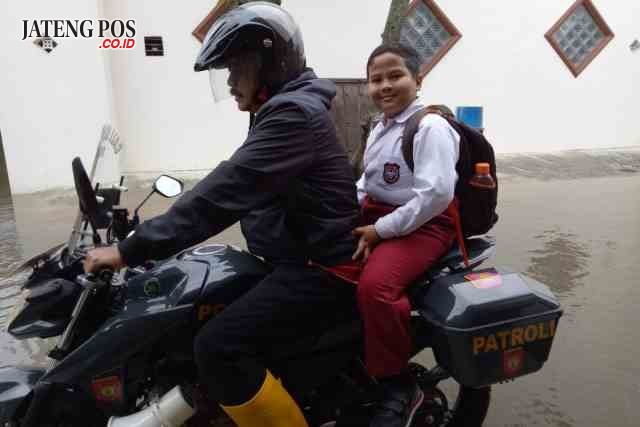 ANTAR – Kapolsek Kompol Agus Riyanto mengantar pelajar SD. (didik teguh r)