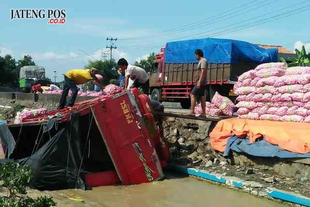 TERGULING: Diduga sopir mengantuk, truk sarat muatan puluhan karung Bawang Putih terjungkal ke sungai irigasi Karangsuno, Cepiring, Kendal, Selasa (09/1).