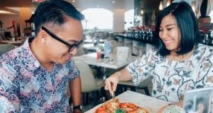 Monica, Public Relation Aston Hotel Semarang tengah melayani tamu yang sedang menikmati Pizza Daging Rendang sebagai menu utama promo Bulan Januari