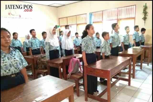 Para siswa SMP 39 saat menyanyikan lagu Indonesia Raya sebelum pelajaran dimulai.