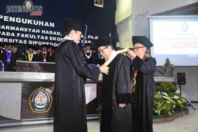 PROSESI PENGUKUHAN: Rektor Undip Prof Yos Johan Utama saat mengukuhkan Gubes Prof Muliaman D Hadad SE MPA PhD, Sabtu(13/1).