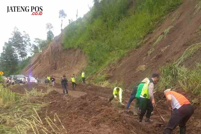 GOTONG ROYONG: Warga dan petugas gotong-royong menyingkirkan tanah longsor yang menutup jalan. Foto : aji jarmaji/jateng pos