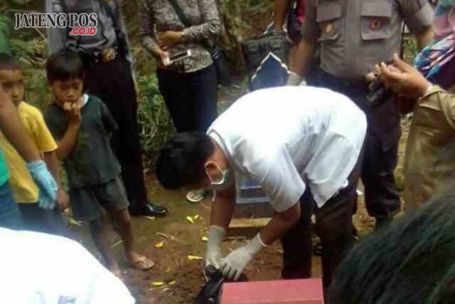 Aparat kepolisian saat melakukan olah TKP penemuan mayat bayi dalam kardus di pemakaman umum Dusun Clorong, Desa Tlogosono Gebang.