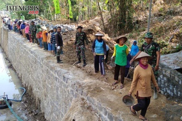 Kebersamaan TNI dan Warga saat bergotong royong bangun embung di Desa Sukorejo. Foto: ARI SUSANTO / JATENG POS