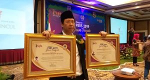 PENGHARGAAN : Henry Indraguna saat menerima dua penghargaan Anugerah Pers 2019 dari PWI Solo di Hotel Lorin Solo, Jumat (15/3) malam.