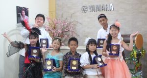 BERPRESTASI : Tujuh anak didik Halmahera Music School Semarang tengah menunjukan piala prestasi Kompetisi Yamaha Electone Festival 2019.