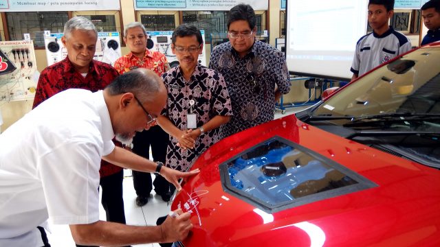 BERI BANTUAN : Presiden Direktur PT Toyota Motor Manufacturing Indonesia, Ir Warih Andang Tjahjono saat membubuhkan tanda tangan pada mobil bantuan untuk pendidikan di SMK 1 Jambu.