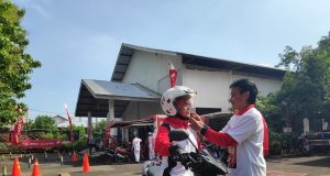 KAMPUNG SAFETY : Lurah Pandean Lamper, Mohamad Tavip memperagakan penggunaan helm yang benar dan aman kepada istrinya, yaitu sampai terdengar bunyi klik di pengait helm. FOTO: Istimewa for jateng pos. (