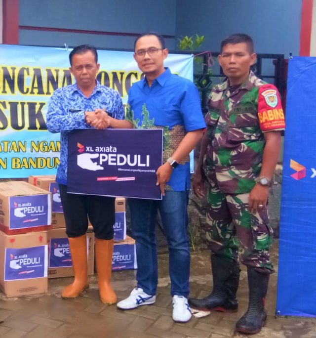 BANTUAN XL: Head of Sales Bandung, Kab Bandung & Kab Bandung Barat XL Axiata, Arif Farhan Budianto (kanan), menyalurkan bantuan air bersih, obat-obatan dan makanan ringan di posko pengungsian korban longsor pada Senin, (17/02). Bantuan diterima secara langsung oleh Kepala Desa Sukatani, Kecamatan Ngamprah, Kabupaten Bandung Barat, Dede Supriadi (kiri). FOTO : IST/ANING KARINDRA/JATENG POS